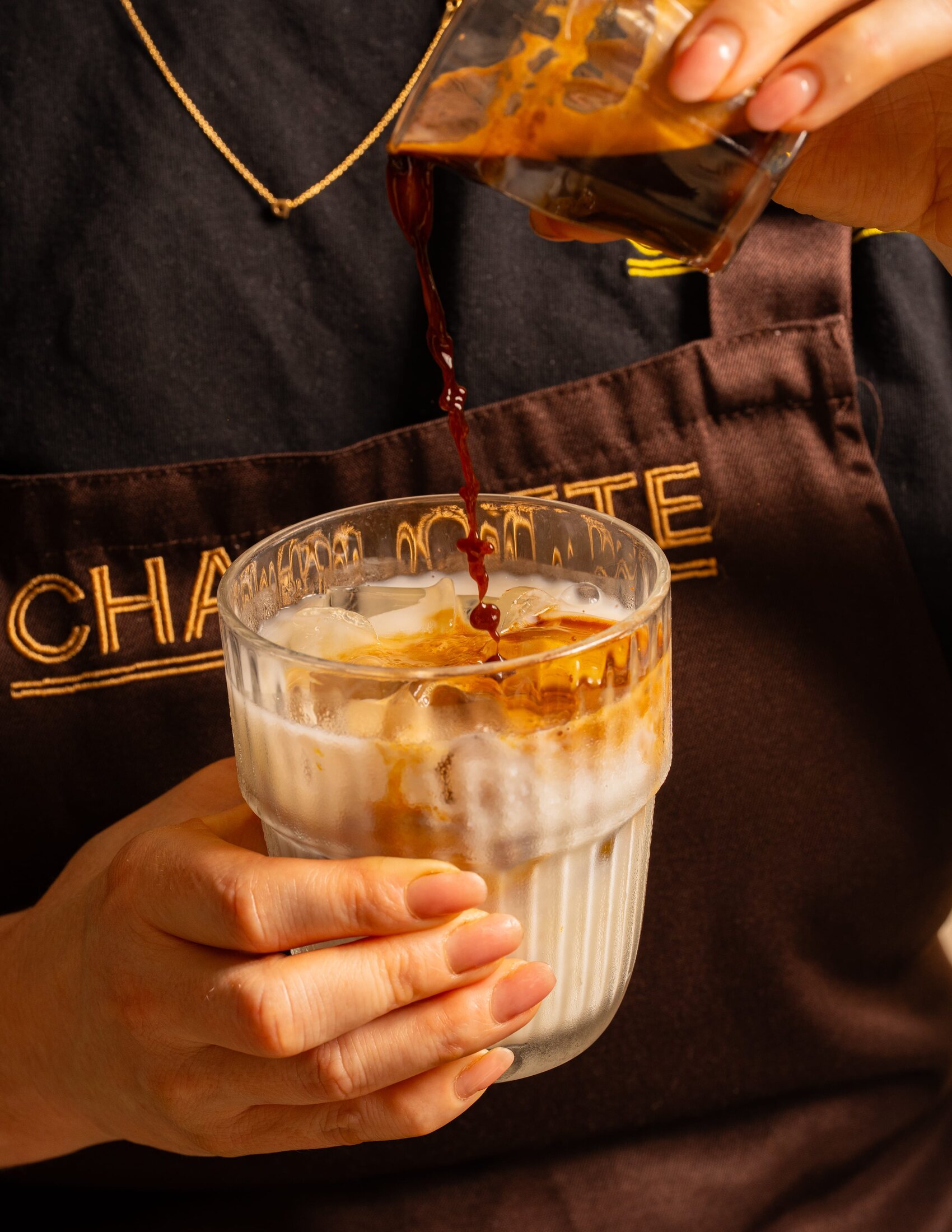 Charlotte team member pouring an iced coffee